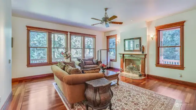 The family room offers a classic charm boasting rich hardwood floors and intricate wood detailing around the windows, enhancing its timeless appeal. At the heart of the room is a beautifully crafted fireplace with an ornate mantle.