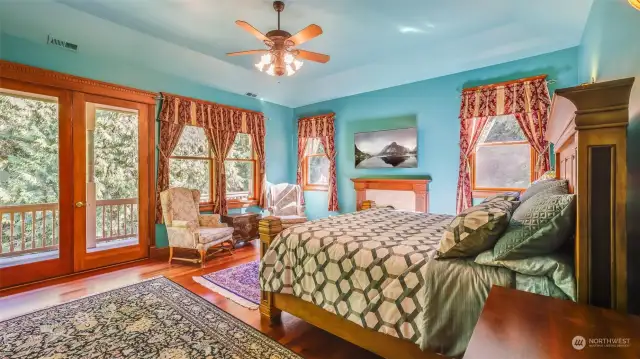 This stunning primary bedroom offers a luxurious retreat with its bright and vibrant atmosphere. French doors open to an expansive deck that provides breathtaking views of the serene surroundings and the lake.