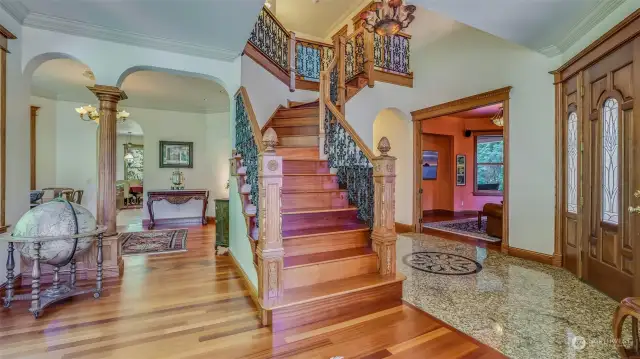 The grand entryway of this stunning Victorian home is a showstopper, featuring a sweeping staircase with ornate woodwork and intricate iron railings. The foyer flows effortlessly into spacious living areas through elegant archways, highlighting the home’s perfect balance of formality and warmth.