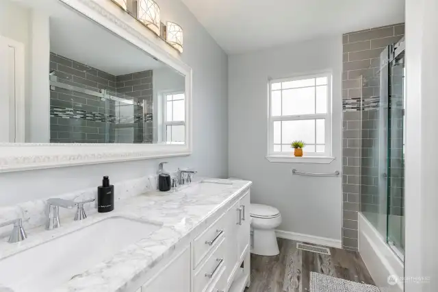 Updated hall bath with tile floors & tub/shower enclosure + 2 sink vanity