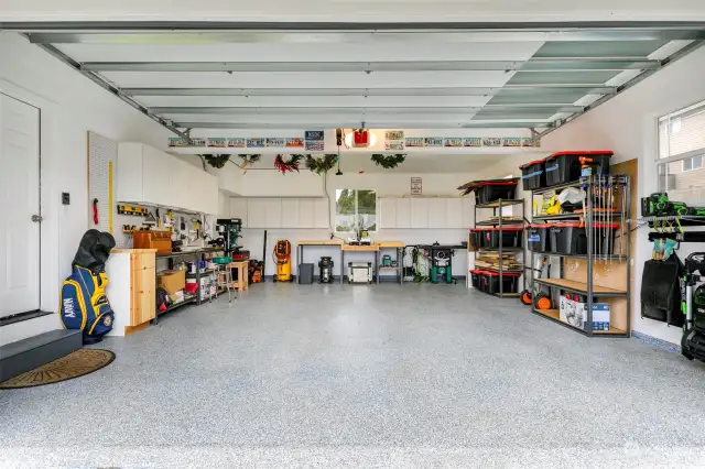 Over-sized garage w/ epoxy floor & great work bench/storage spaces + backyard views.