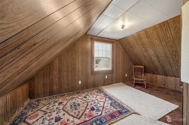 Partially finished attic where you'll find a cozy reading nook, the perfect hideaway for those who enjoy getting lost in a good book. With natural light streaming through the windows overlooking Clark's Creek, the backyard & deck. This peaceful retreat offers a quiet space for reflection or relaxation. Current seller used this as an office space. To the left of this photo is additional attic storage space.