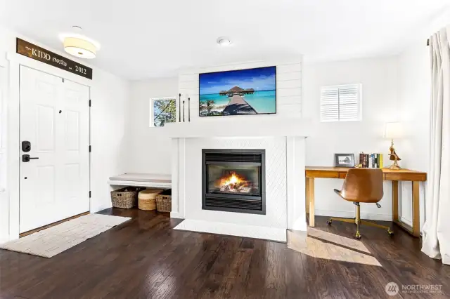 Modernized tile surround fireplace with built in bench and shiplap accents above.