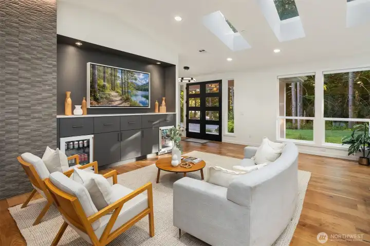 The great room showcases a stunning gas fireplace, dual built-in Perlick beverage centers, automated lighting with multiple functions, and fully integrated audio and motorized blinds