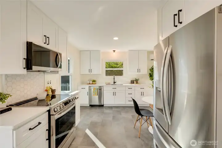 Kitchen with quartz countertops and a tile splash guard behind the range.