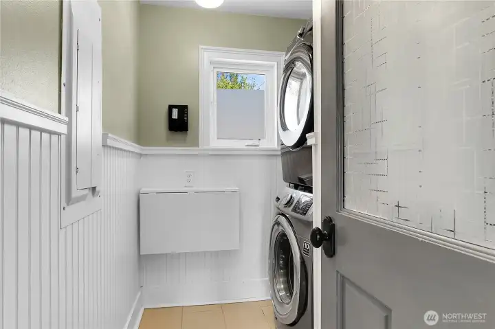 Laundry room equipped with a full-size stackable washer and dryer for efficient, space-conscious living.
