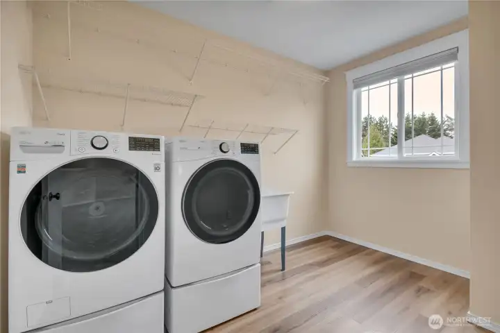 Laundry Room with storage shelves, utility sink, and LG ThinQ Washer and Dryer Set