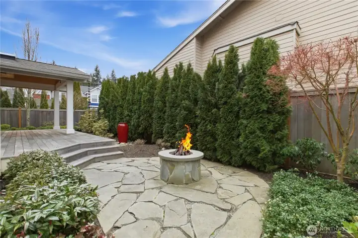 Gas fire pit with custom log sculpture surrounded by flagstone for cozy gatherings