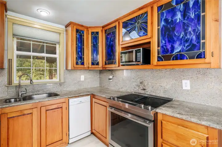 Custom cabinetry with stained glass fronts & slab granite counters & back splash!