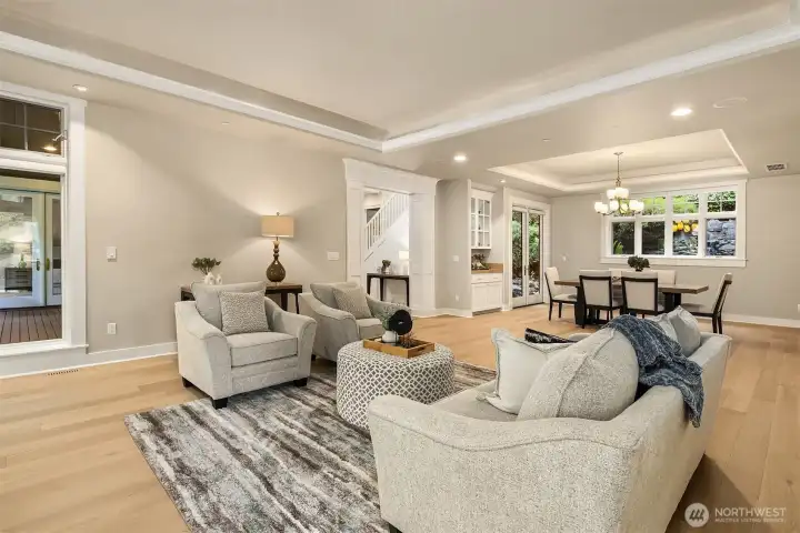 Generously proportioned, this formal living space connects to the dining room and opens to two deck access points, with serene green outlooks on all sides.