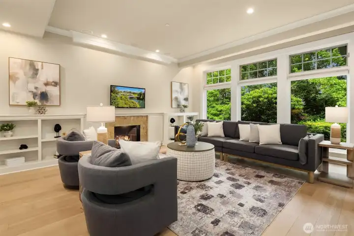 The family room - anchored by a second Valor fireplace, custom built-ins, and a wall of windows - is where everyday life unfolds.
