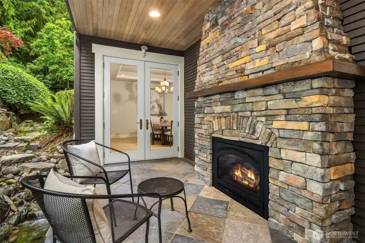 The covered patio, warmed by a stacked-stone Valor gas fireplace, blurs the line between interior comfort and the natural world.
