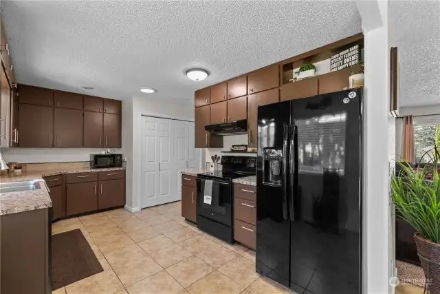 Spacious kitchen with lots of cabinets and tile flooring