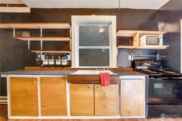 The kitchen includes a stone countertop, an oven-range, and refrigerator-freezer.