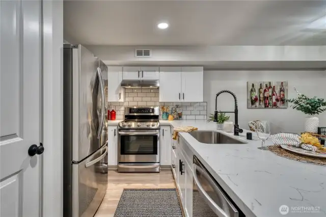 Light and bright brand new kitchen. Fresh white shaker cabinets, quartz tops and fun backsplash.
