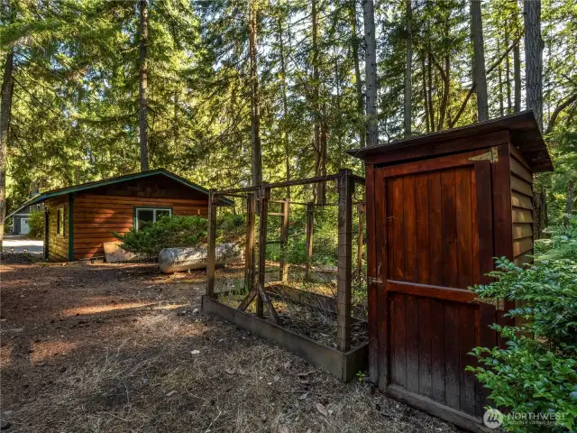 Just behind the garage, you'll find the garden area with fenced-in garden beds and the garden shed.