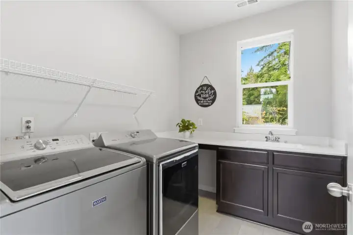 Efficient laundry room with storage, sink, counter space, natural light... all on the second floor for easy access to/from bedrooms.