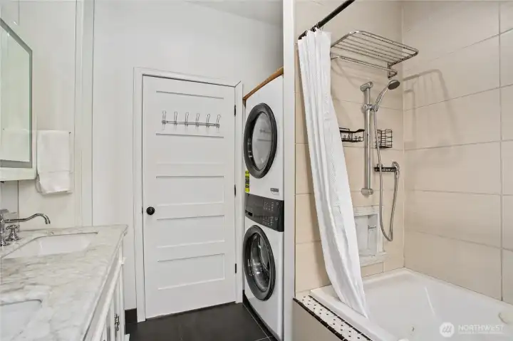 The spacious main-floor bathroom offers convenient laundry- new Electrolux washer & dryer-2025.