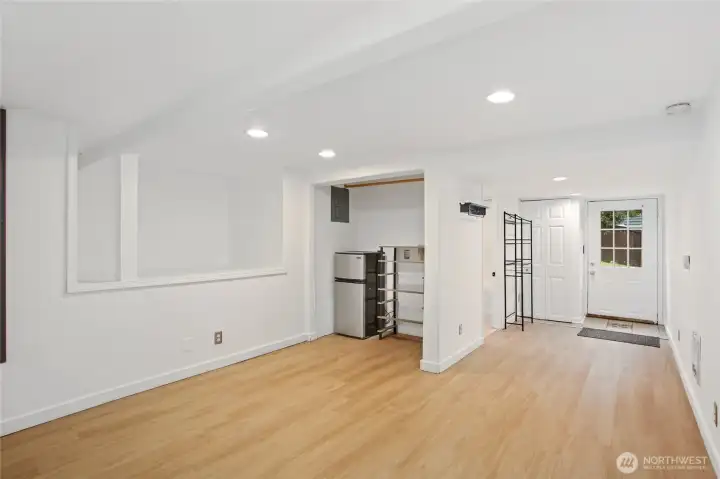 Another view of the lower-level, showcasing, laminate flooring, a separate electric panel, hook-ups for laundry and a full second bathroom.