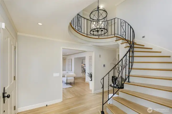 Elegant high ceiling entry way with curved staircase
