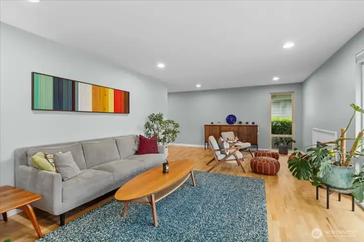 Step into the light and bright living room with oversized windows, hardwood floors and a fireplace to cozy up to on cool evenings