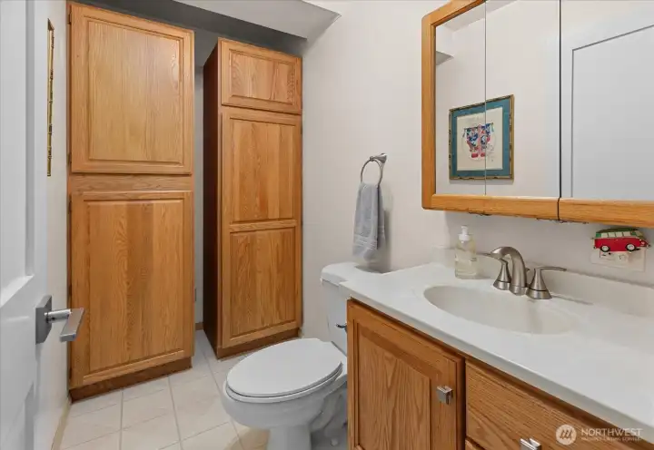 Lower level guest half bathroom with storage cabinets
