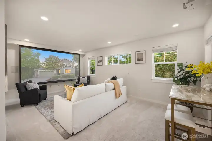 A massive flex/bonus room equipped with a 120-inch projection screen, projector, surround sound, and room-darkening shades offers exceptional space for media, recreation, hobbies, or storage.