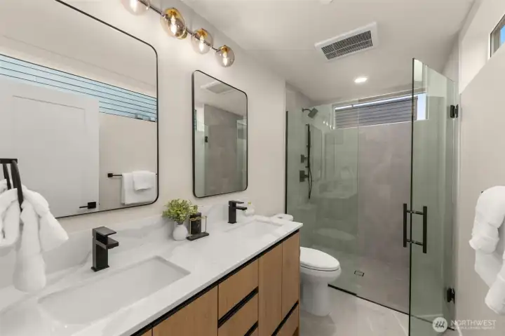 Spa-inspired primary bathroom with a clean floating vanity, crisp white subway tile surround, and modern black plumbing fixtures. Spa-inspired primary bathroom with a clean floating vanity, crisp white subway tile surround, and modern black plumbing fixtures.