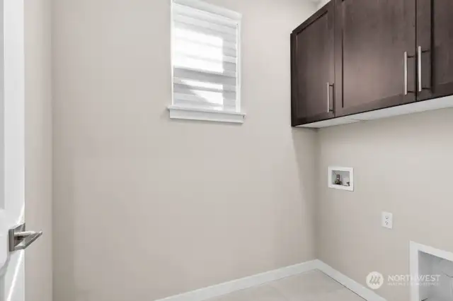 Upstairs laundry room with built in cabinets.