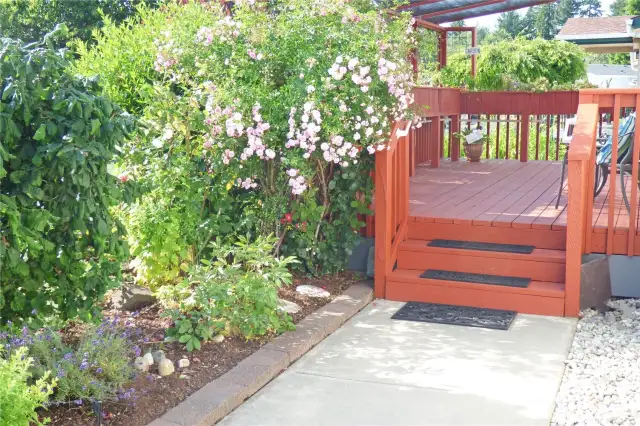 Walk up to the front deck past the beautiful yarden with sprinkler system.