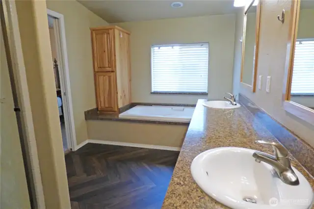 Other side of primary bathroom. Notice the large tub and extra cabinets. Shower to te left.