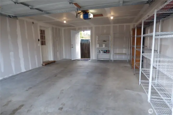 Double garage with door on left to inside and open door to outside. Remote garage door and shelving too.