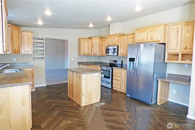 The other side of the kitchen with stainless appliances and a desk for paying bills or planning meals.