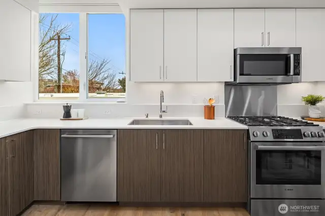 Quartz counters and stainless appliances with gas range and microwave built in over range.