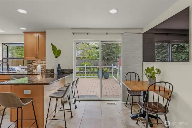 Eat-in kitchen with space for counter height stools and small table with sliding door access to backyard.