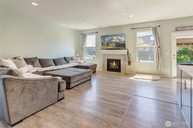 Cozy up in the spacious living room featuring a gas fireplace, abundant natural light, and plenty of room to relax or entertain.