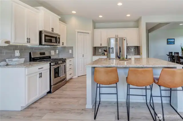 Sleek, stylish, and smartly designed—this kitchen features stainless steel appliances, granite countertops, subway tile backsplash, and a spacious island perfect for prep, dining, or gathering.