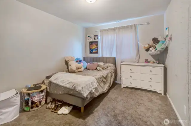 Cozy and comfortable, this secondary bedroom offers plush carpet, soft natural light, and the perfect space for rest, play, or creative expression.