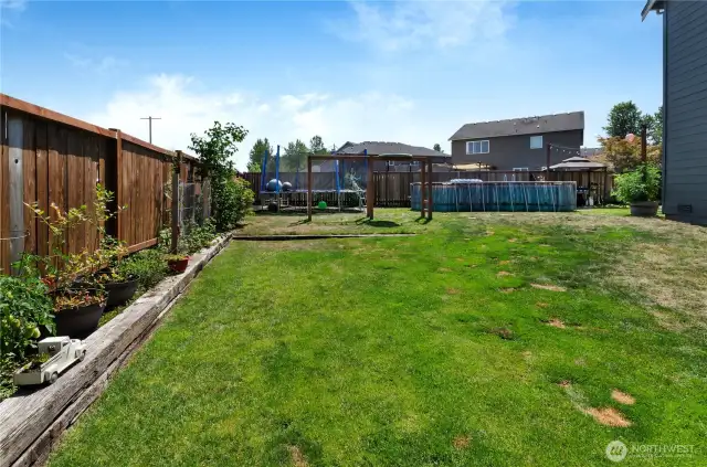 Spacious and fully fenced, this backyard is the ultimate play zone—featuring a large grassy area, swing set, above-ground pool, and garden space. There's room for everyone to enjoy the outdoors!