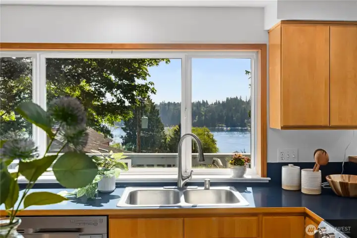 The upper level deck runs the length of the kitchen and dining area. Open the window and converse with guests as they gaze at your view!