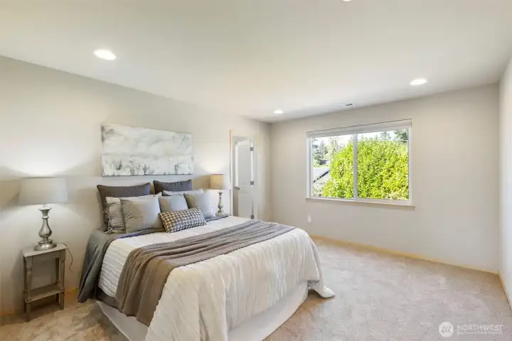 Primary suite retreat with soft new carpet and private bath.