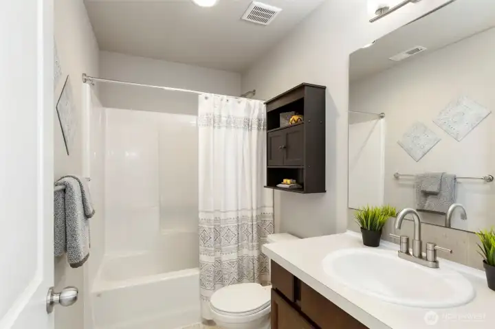 Full bath with tub, shower, and fresh finishes.