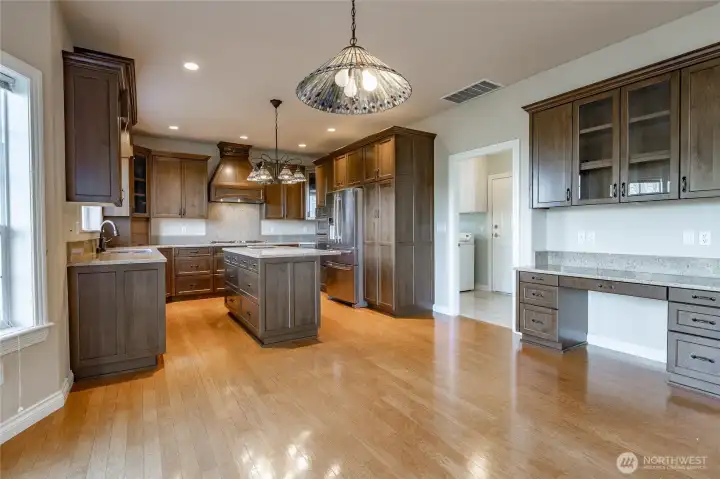 Beautiful Kitchen with deluxe cabinets and Quartz counters. Door to the right goes to the half bathroom, laundry room, and through to the garage.walking straight through goes to the formal dining/Family Room.