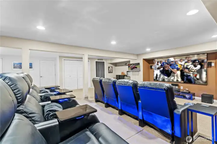 Large basement space designed for family time and entertaining features a full theater setup—ideal for movie nights, game days, and gatherings with friends and family.