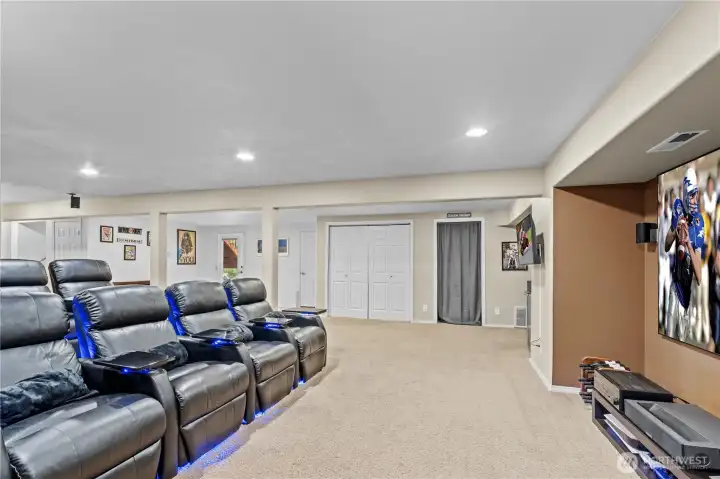 Large basement space designed for family time and entertaining features a full theater setup—ideal for movie nights, game days, and gatherings with friends and family.