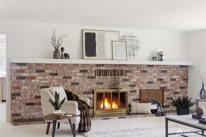The wall-to-wall brick wood-burning fireplace is a beautiful centerpiece of the living room, with a mantle for displaying art and sentimental pieces.