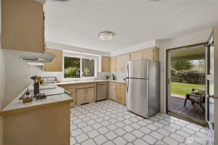 A convenient door to the covered back deck is beside the kitchen. Ideal for hosting BBQs and outdoor gatherings!
