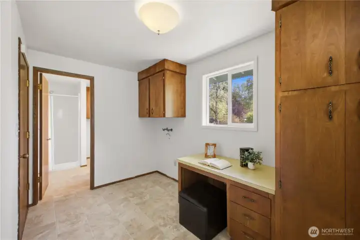 This laundry room offers extra storage space, and has an exterior door to the side of the home. It leads to the attached garage and the 3/4 bath through the doorway ahead.