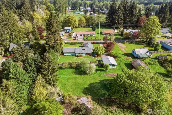 Surrounding the home are mature trees, privacy shrubs, and flowering bushes. The rhodies are just starting to blossom!