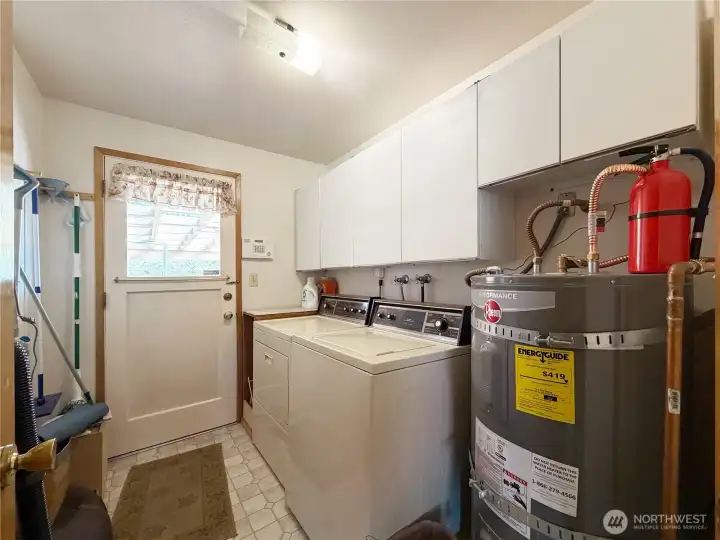 Laundry with door to the deck and backyard